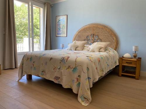 a bedroom with a large bed with a wicker headboard at Le Repos du Keyrié in Saint-Marc-Jaumegarde