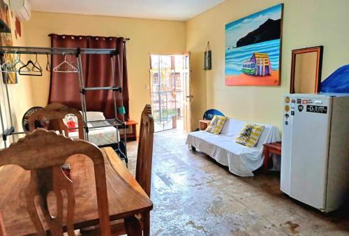 um quarto com um frigorífico, uma mesa e uma cama em Hostel Rossy em San Juan del Sur