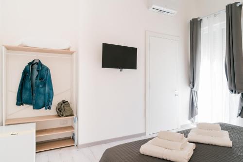 a bedroom with a mirror and a bed with two towels at FG Vacanze in Alghero