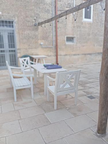 a white table and chairs on a patio at Casolare Giardino Aiarella-Assunta in Merine