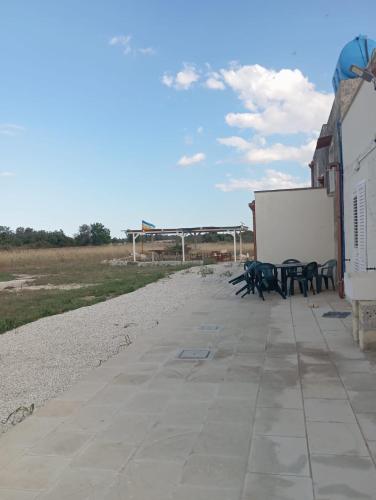 a sidewalk with picnic tables and a white screen at Casolare Giardino Aiarella-Assunta in Merine