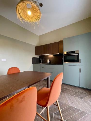 - une cuisine avec une table en bois et des chaises orange dans l'établissement Appartement moderne avec une belle vue, à Nice