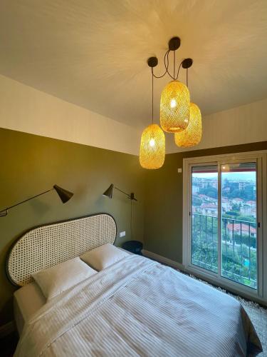 - une chambre avec un lit, deux lumières et une fenêtre dans l'établissement Appartement moderne avec une belle vue, à Nice