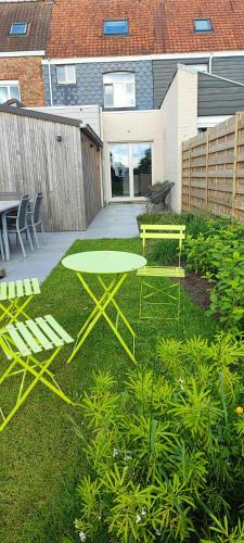 a green table and bench in a yard at Maison Rose Plopsaland in De Panne