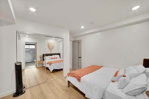 a white bedroom with a bed and a mirror at Brand new Chic-Nest in Prime Location in Sherman Oaks