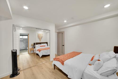 a white bedroom with a bed and a mirror at Brand new Chic-Nest in Prime Location in Sherman Oaks
