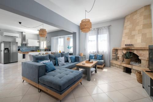 a living room with blue furniture and a fireplace at Villa Bella with Private Pool and Hot Tub in Lardos