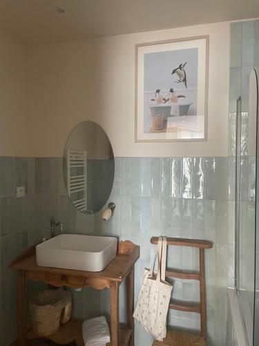 een badkamer met een wastafel en een spiegel bij -Les Petites Planches- Gîte Familial entre Terre & Mer in La Haye-Pesnel