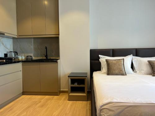 a bedroom with a bed next to a kitchen at Coastline Luxury Apart Hotel in Golem