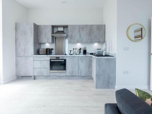a kitchen with stainless steel appliances and a couch at Leeds Haven Niche 1 2 Bedroom Apartments with Cityscape views by Belvilla in Leeds