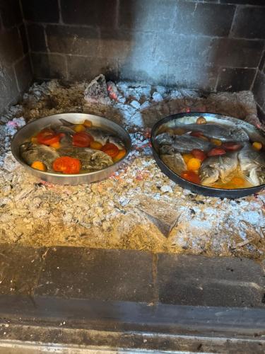 tres sartenes de comida en la parte superior de un horno de ladrillo en Qyteza Guest House & Camping en Shkodër