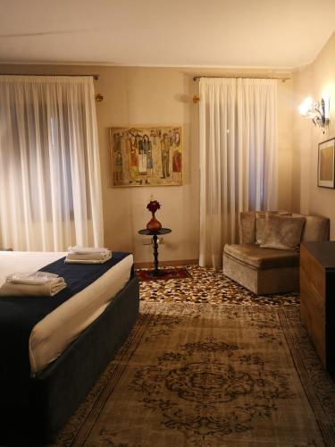 a bedroom with a bed and a couch and a chair at Cinqueteste Luxury Home in Venice