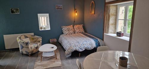 une chambre avec un lit, une table et une chaise dans l'établissement Au doux rêve, à Puyfebert