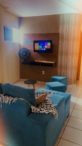a living room with a blue couch and a tv at Apê da VAN in Garanhuns