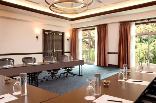 a conference room with tables and chairs and windows at Hotel Contessa - Suites on the Riverwalk in San Antonio