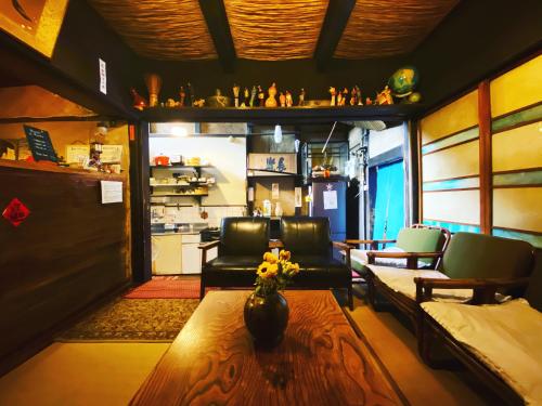 a living room with a couch and chairs and a table at Hostel Mundo in Kyoto