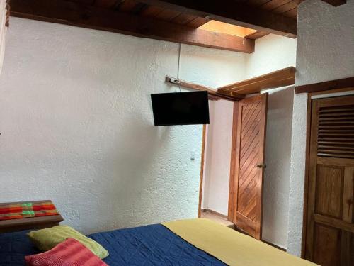 Un dormitorio con una cama y un televisor en la pared. en Departamentos en Avandaro, en Valle de Bravo