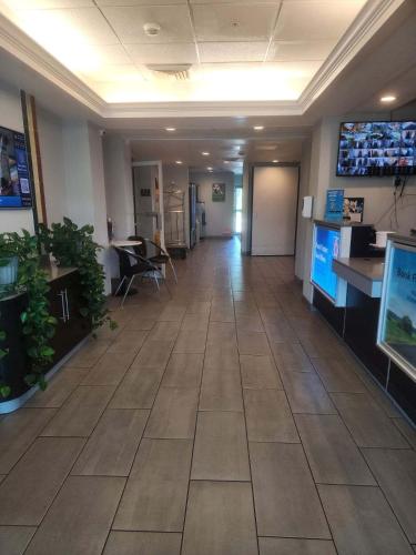 a hallway in a office with a large tile floor at Motel 6-West Des Moines, IA in West Des Moines