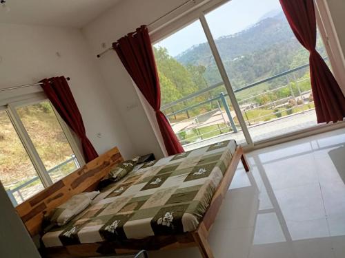 a bedroom with a bed and a large window at Trails of Bheta in Kausani
