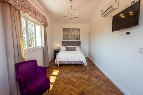 a bedroom with a bed and a purple chair at La Santa Hotel Boutique in Mendiolaza