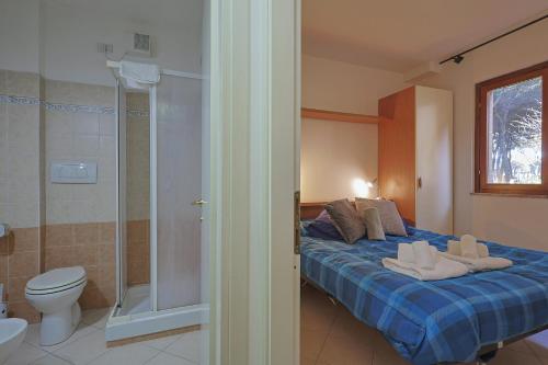 マリーナ・ディ・グロッセートにあるPineta Azzurraのベッドルーム1室(ベッド1台、シャワー、トイレ付)