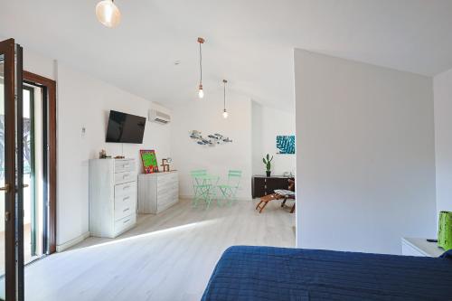 ein weißes Schlafzimmer mit einem blauen Bett und einem Schreibtisch in der Unterkunft Pineta Azzurra in Marina di Grosseto