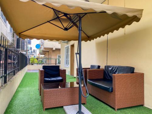 a patio with two chairs under an umbrella at Sammy's Place in Lekki
