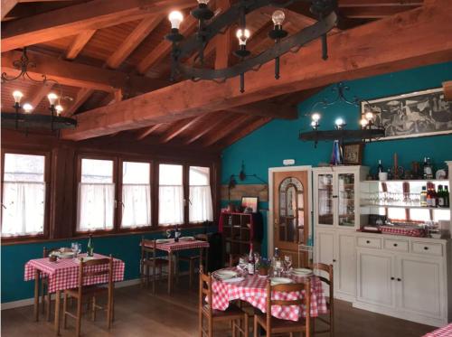 Zubietako Ostatua في Zubieta: غرفة طعام مع طاولات وكراسي وجدران زرقاء