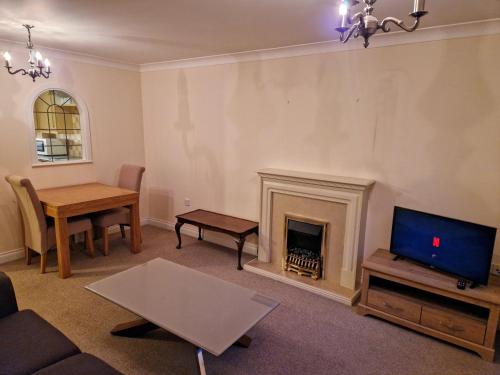 a living room with a fireplace and a tv at Dellside Apartments in Southampton