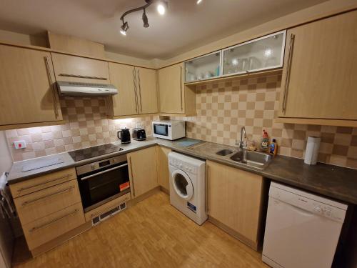 a kitchen with a washer and a sink and a dishwasher at Dellside Apartments in Southampton
