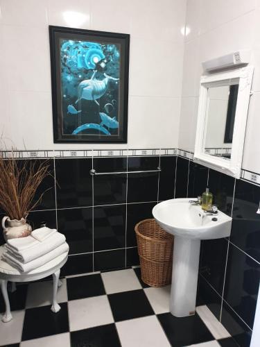 - une salle de bains en noir et blanc avec lavabo et miroir dans l'établissement Hillside Residence, à Carrick-on-Shannon