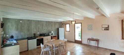 une cuisine avec une table et des chaises dans une pièce dans l'établissement gite des voisins, à Pradons