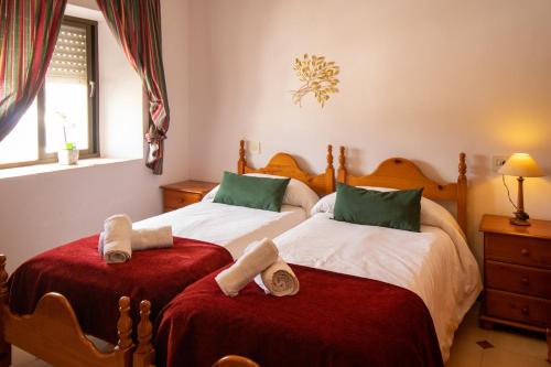 a bedroom with two beds with towels on them at La Casa de la Lela in Setenil