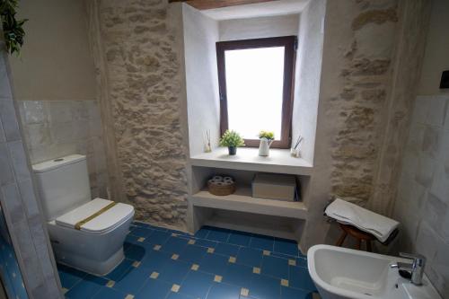 łazienka z toaletą i oknem w obiekcie La Casa de la Lela w mieście Setenil