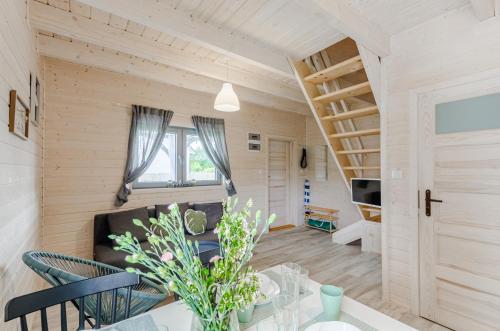 a living room with a couch and a staircase at Biale Domki Kopalino in Kopalino