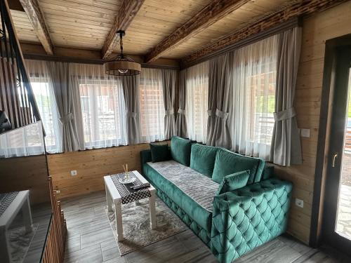 a living room with a green couch and a table at Zagrad Homes in Zabljak in Žabljak