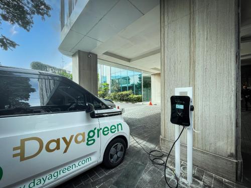 a white electric car is plugged into a building at Crowne Plaza Bandung by IHG in Bandung