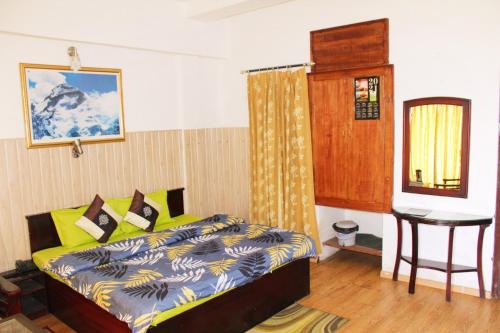 a bedroom with a bed and a table in it at Jaishnavi Homestay And Restaurant in Mukteswar