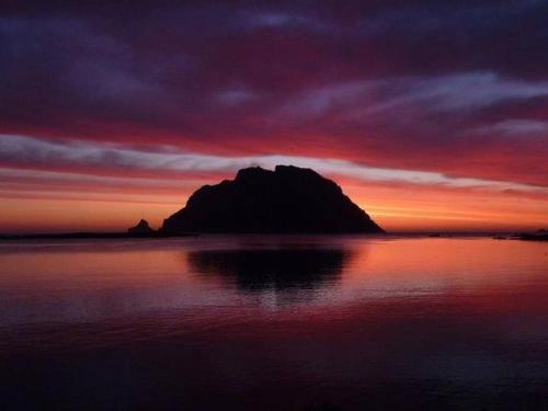 a mountain in the middle of the water at sunset at Porto San Paolo a 50 mt dal mare in Porto San Paolo