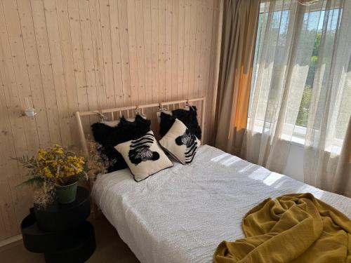 Un dormitorio con una cama con almohadas y una ventana. en Seaside luxury apartment, en Tuja
