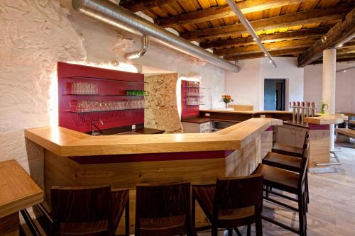 a kitchen with a bar with chairs and tables at Schatz.Kammer Burg Kreuzen in Bad Kreuzen