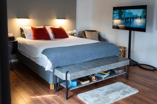 a bedroom with a bed with a tv on the wall at Central Charming Studio Apartment in Jerusalem in Jerusalem