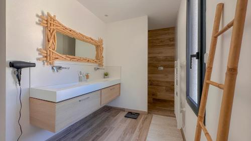 une salle de bain avec un lavabo et un miroir au mur dans l'établissement Villa contemporaine avec piscine - 170m2, à Sauzet