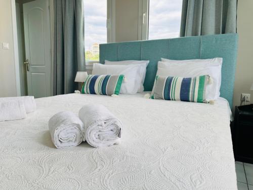 a bedroom with a bed with towels on it at Sea Breeze Apartments Chios in Monolia