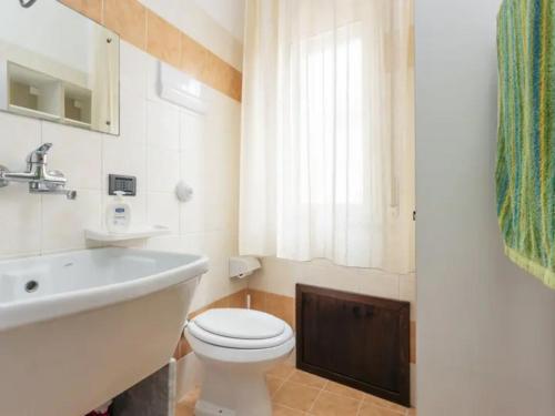 uma casa de banho com um WC branco e um lavatório. em CASA VACANZE PERLA em Partinico