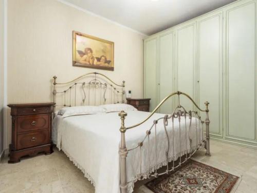 um quarto com uma cama branca e um quadro na parede em CASA VACANZE PERLA em Partinico