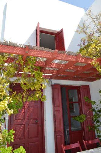 una casa con una puerta roja y un techo rojo en The Red-Fish House en Astipalea
