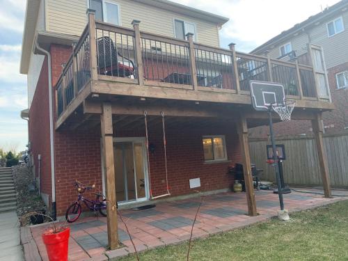a deck on a house with a basketball hoop at Lower Unit Entire Apartment in Cambridge
