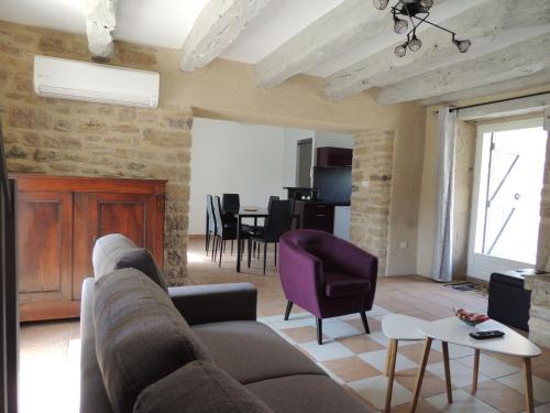 - un salon avec un canapé et un fauteuil violet dans l'établissement Mas de Rossignol, à Vailhourles