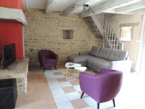 un salon avec un canapé et des chaises violettes dans l'établissement Mas de Rossignol, à Vailhourles